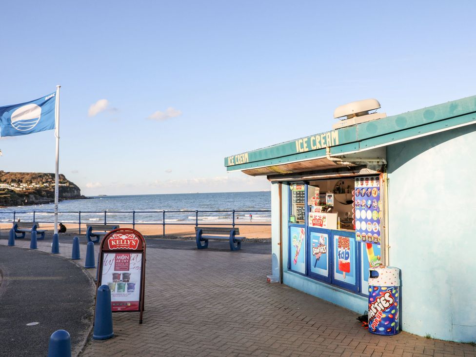 An ice cream kiosk near the beach with seating area at Meadow View in Benllech