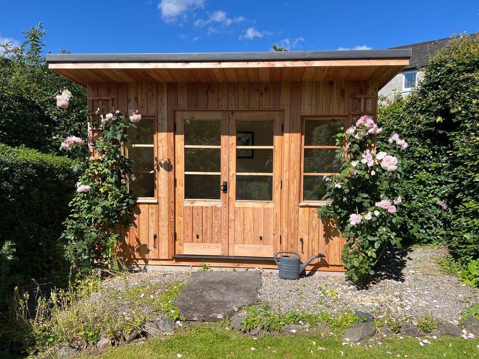 A wooden shed with plants outside in the garden at Grisedale View Keswick