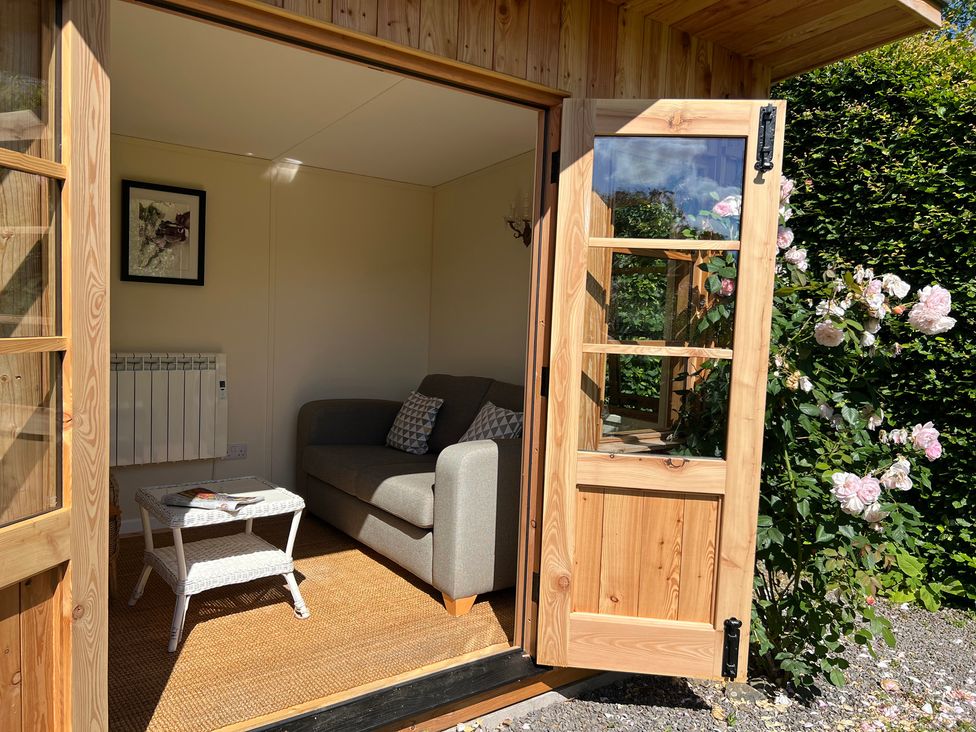 A snug with a sofa, table and framed picture at Grisedale View in Keswick