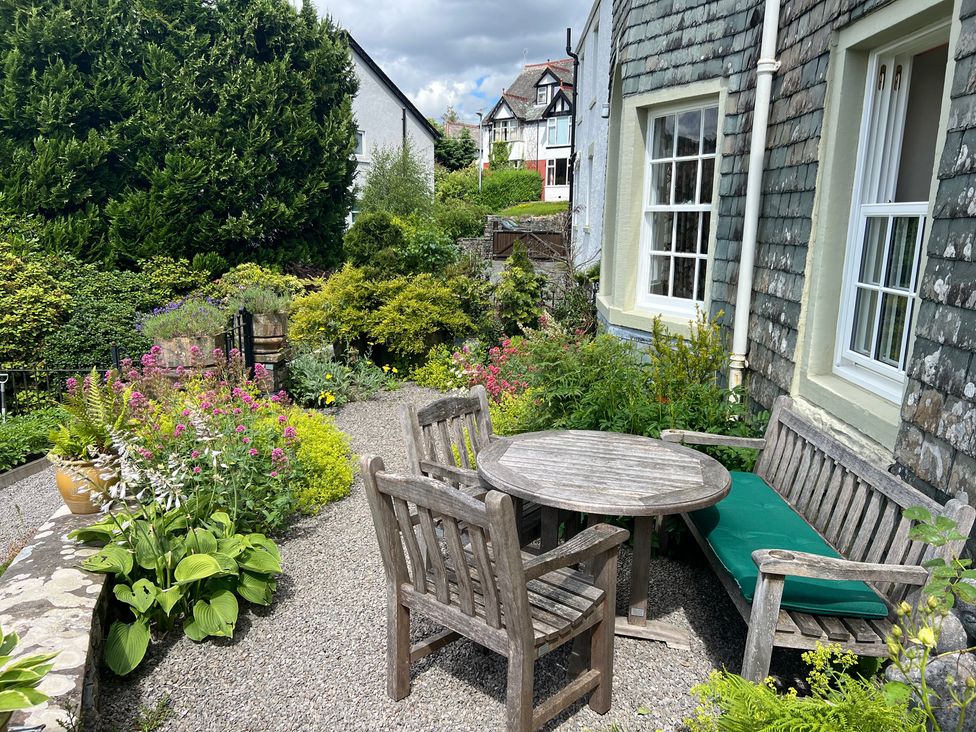 A garden with a table and chairs surrounded by various plants at Grisedale View in Keswick