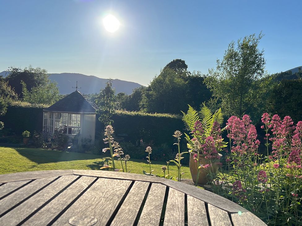 A garden with flowers and a shed at Grisedale View in Keswick