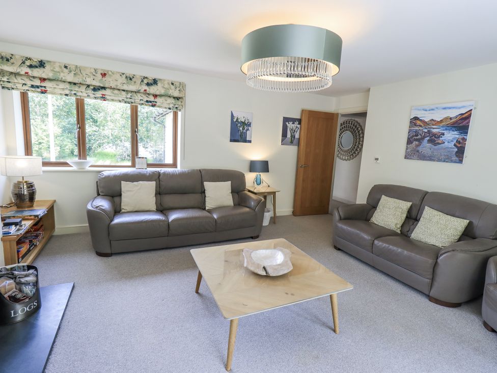 A living room with a sofa, coffee table, and lamp at No 7 in Ambleside