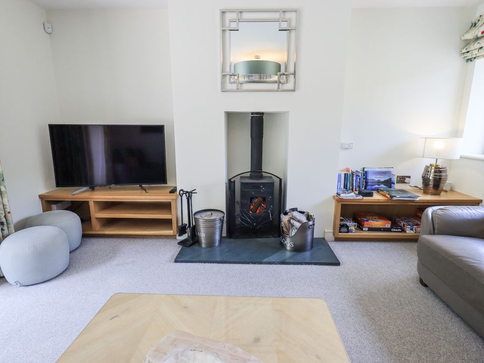 A living room with a television and wood stove at No 7 Ambleside