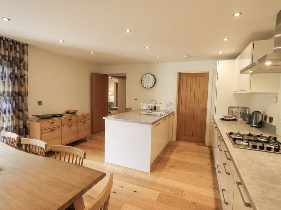 A kitchen with a dining table and cabinet at No 7 in Ambleside