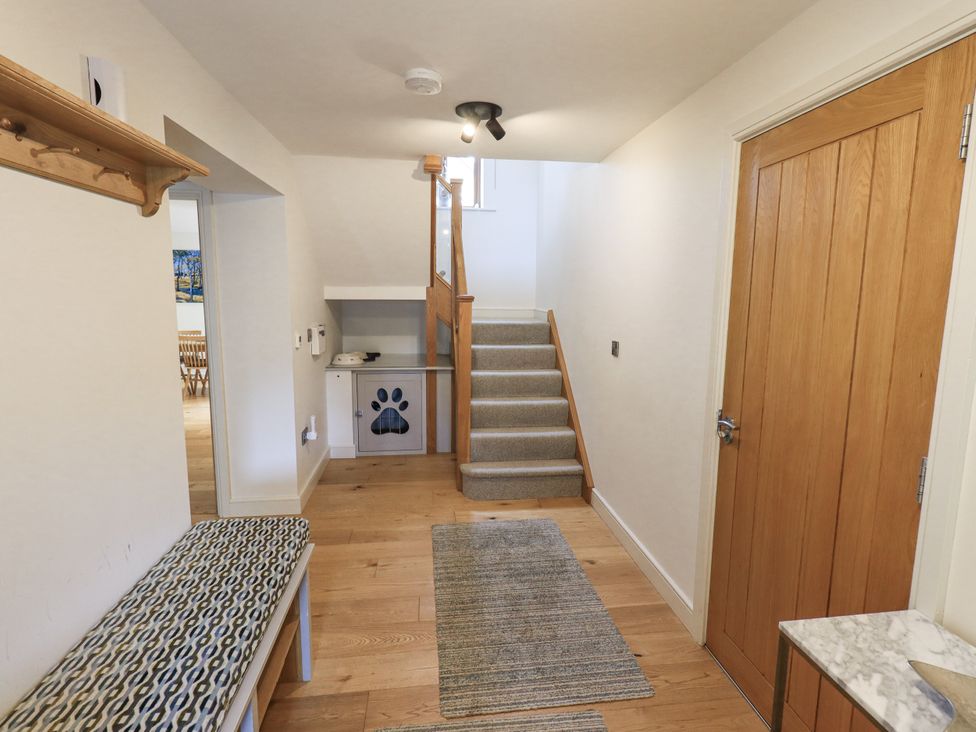 A hallway with a staircase and bench at No 7 Ambleside