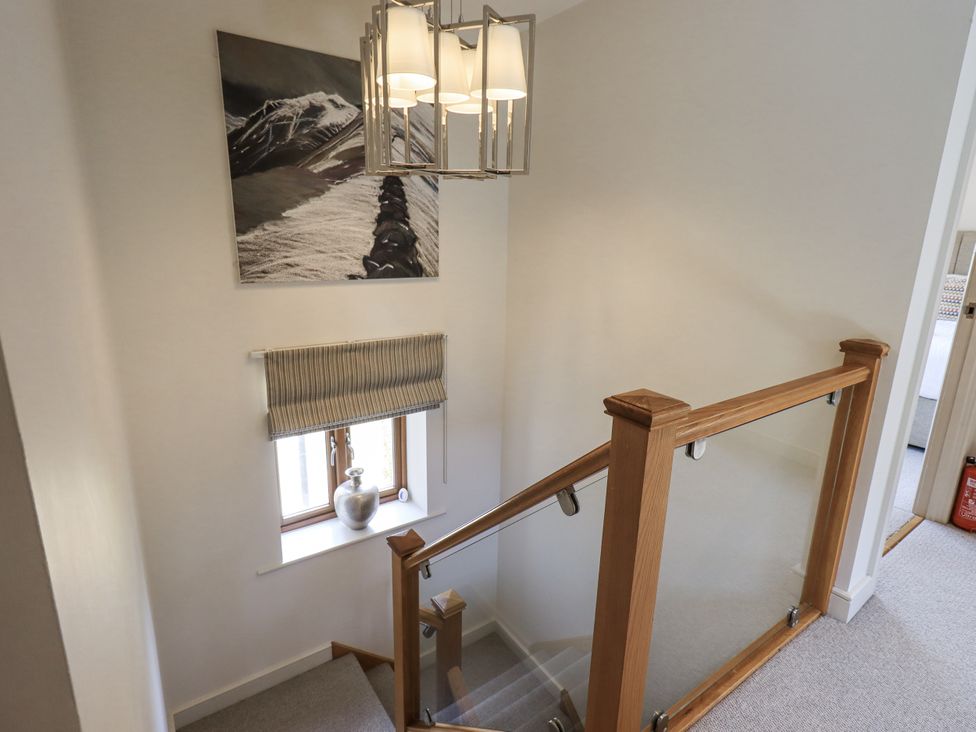 A staircase with a hanging light and a window in the hallway at No 7 Ambleside