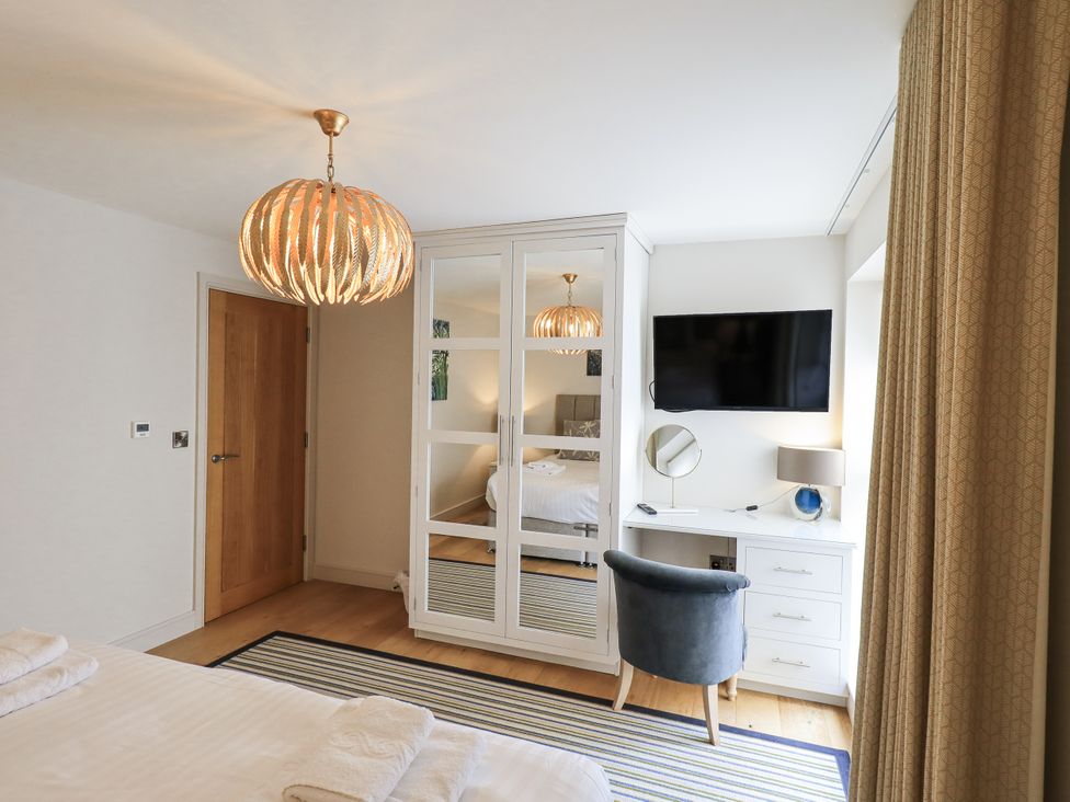 A bedroom with a wardrobe and television at No 7 in Ambleside