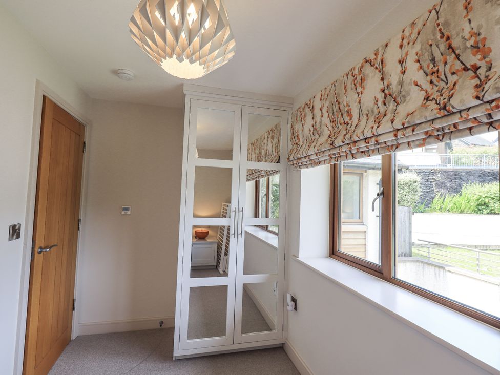 A bedroom with a mirror cabinet and window at No 7 in Ambleside