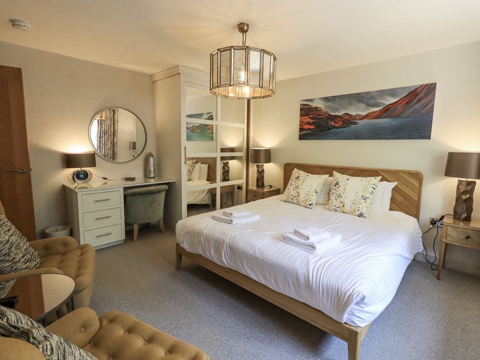 A bedroom with a bed and seating area at No 7 in Ambleside