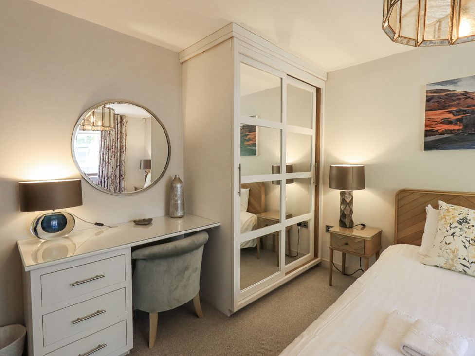 A bedroom with a bed, desk, and mirror at No 7 in Ambleside