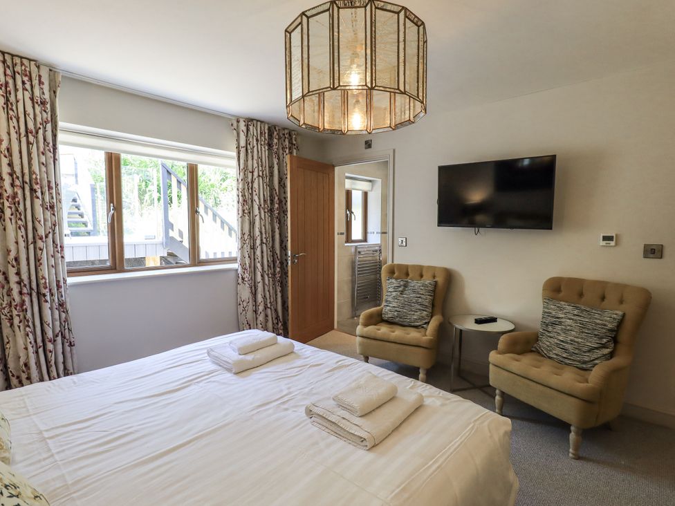 A bedroom with a bed and two chairs at No 7 Ambleside