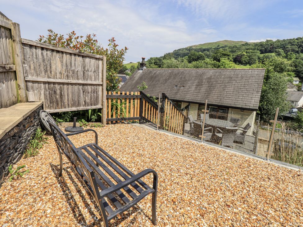 A garden with a bench and gravel at No 7 in Ambleside