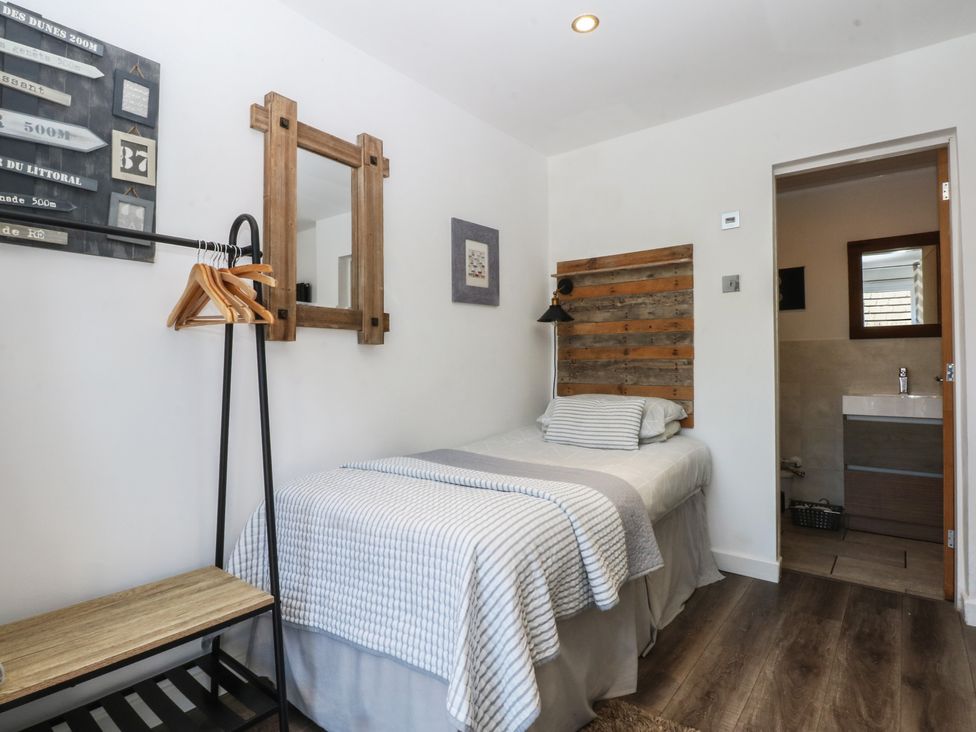 A bedroom with a single bed and a bathroom door at Sea View in Llandudno