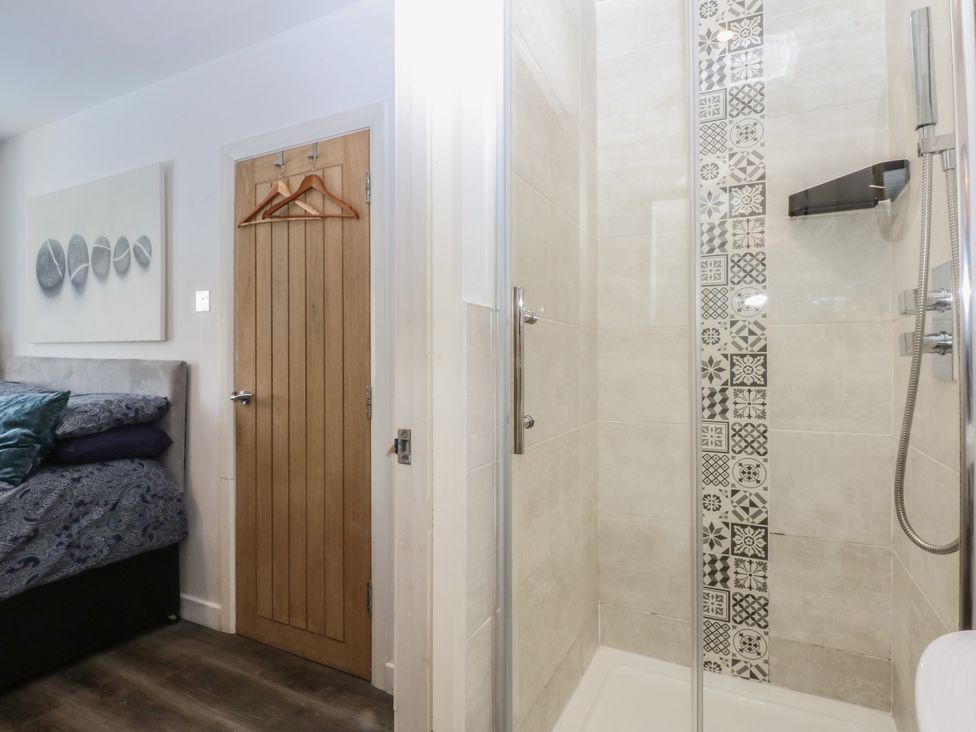A bathroom with a shower and toilet door at Sea View in Llandudno