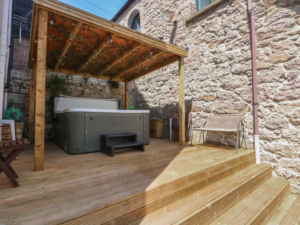 An outdoor area with a hot tub and wooden seating at Sea View in Llandudno