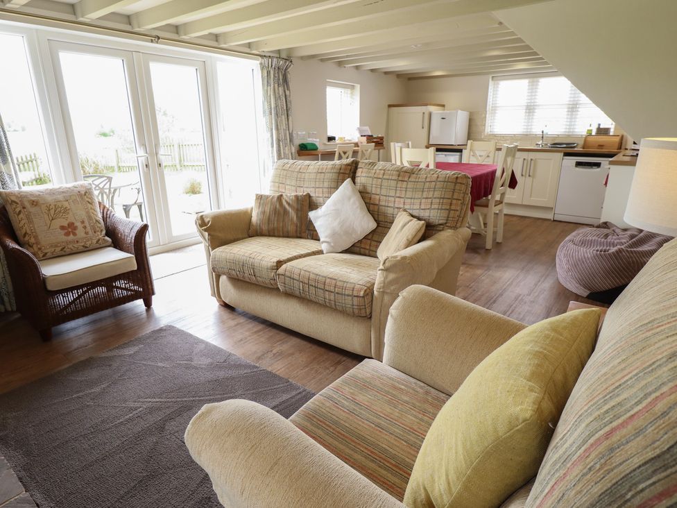 A living room with a sofa and armchair at Shepherd's Cottage in Claythorpe near Alford