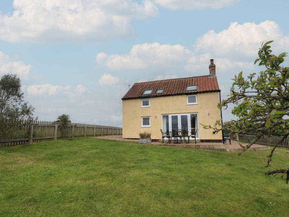 A house with a garden and outdoor seating at Shepherd's Cottage in Claythorpe near Alford
