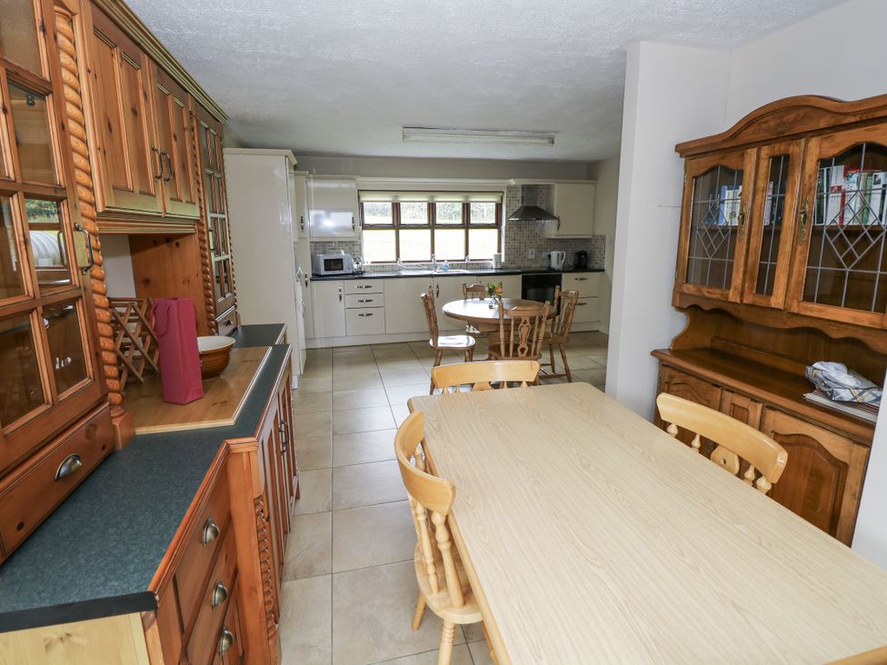 A kitchen with wooden cabinets and dining table at Brow O' The Hill in Ballyshannon