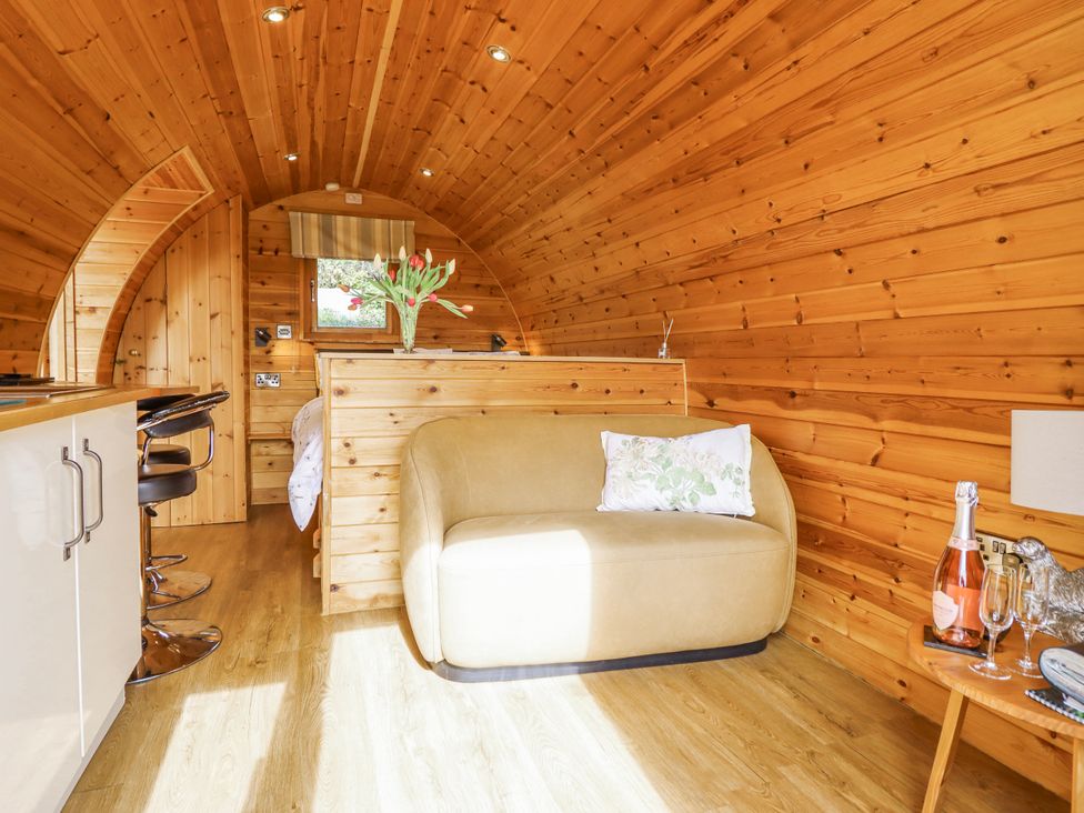 A bedroom with a sofa and kitchen counter at The Rhiw in Llanfair Caereinion