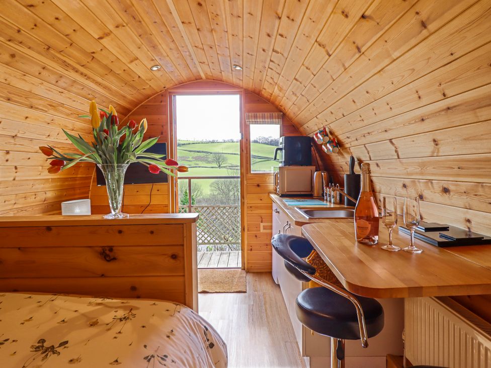 A studio with a wood interior and a door opening to a view at The Rhiw in Llanfair Caereinion