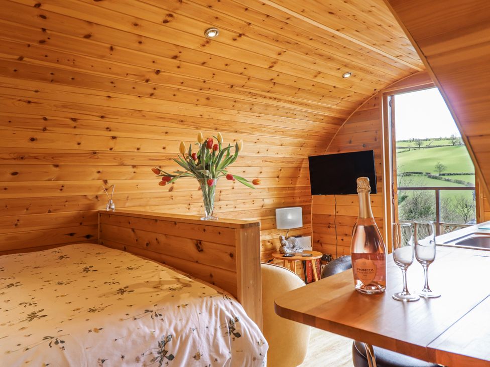 A bedroom with a bed and a table at The Rhiw in Llanfair Caereinion