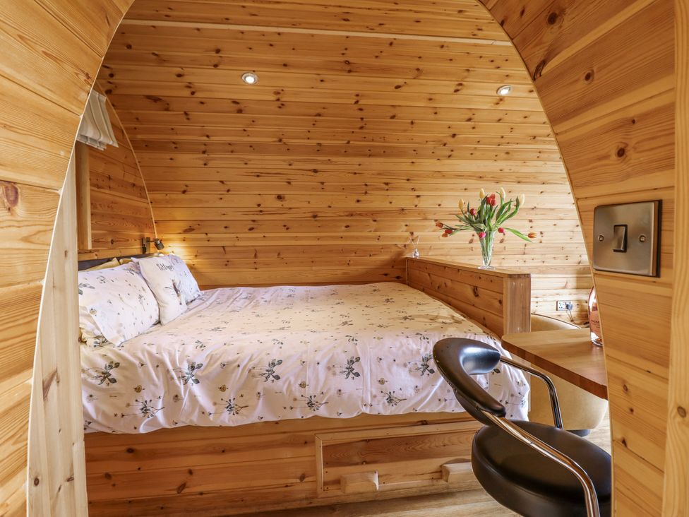 A bedroom with a bed and a table at The Rhiw in Llanfair Caereinion