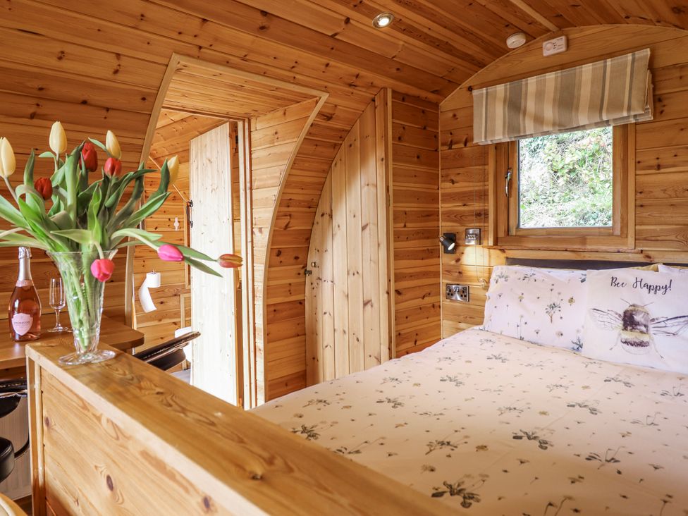 A bedroom with a bed and flowers at The Rhiw in Llanfair Caereinion