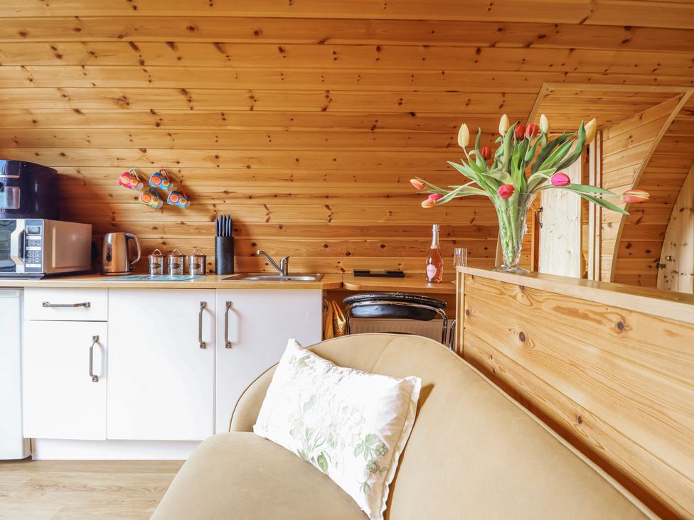 A kitchen area with a microwave and kettle at The Rhiw in Llanfair Caereinion