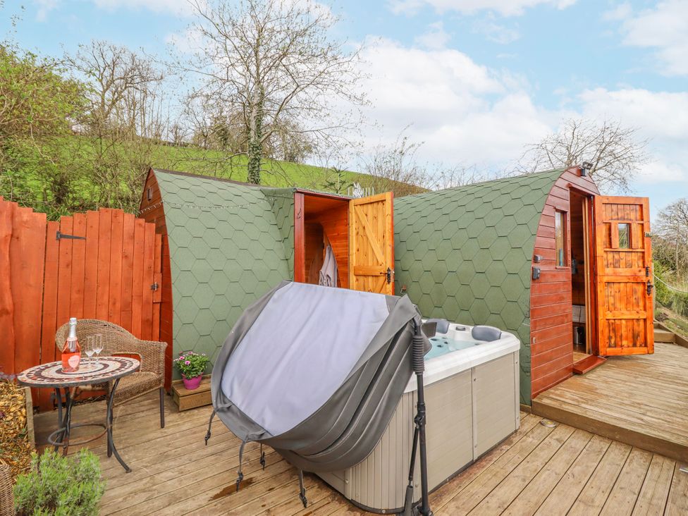 An outdoor area with a hot tub and wooden structures at The Rhiw in Llanfair Caereinion