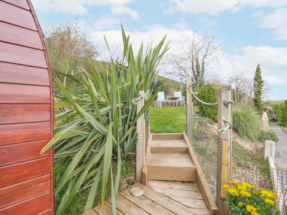 A garden with wooden steps and outdoor seating area at The Rhiw in Llanfair Caereinion