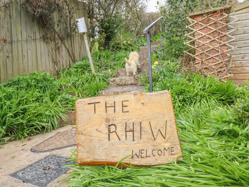 A garden with a welcome sign and steps at The Rhiw in Llanfair Caereinion