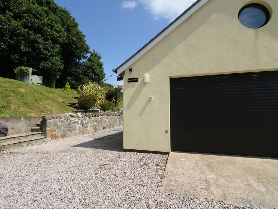 A garage door and stone wall at Ettrick Cottage in Rothesay