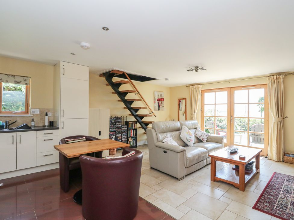 A living room with a sofa and dining table at Ettrick Cottage in Rothesay
