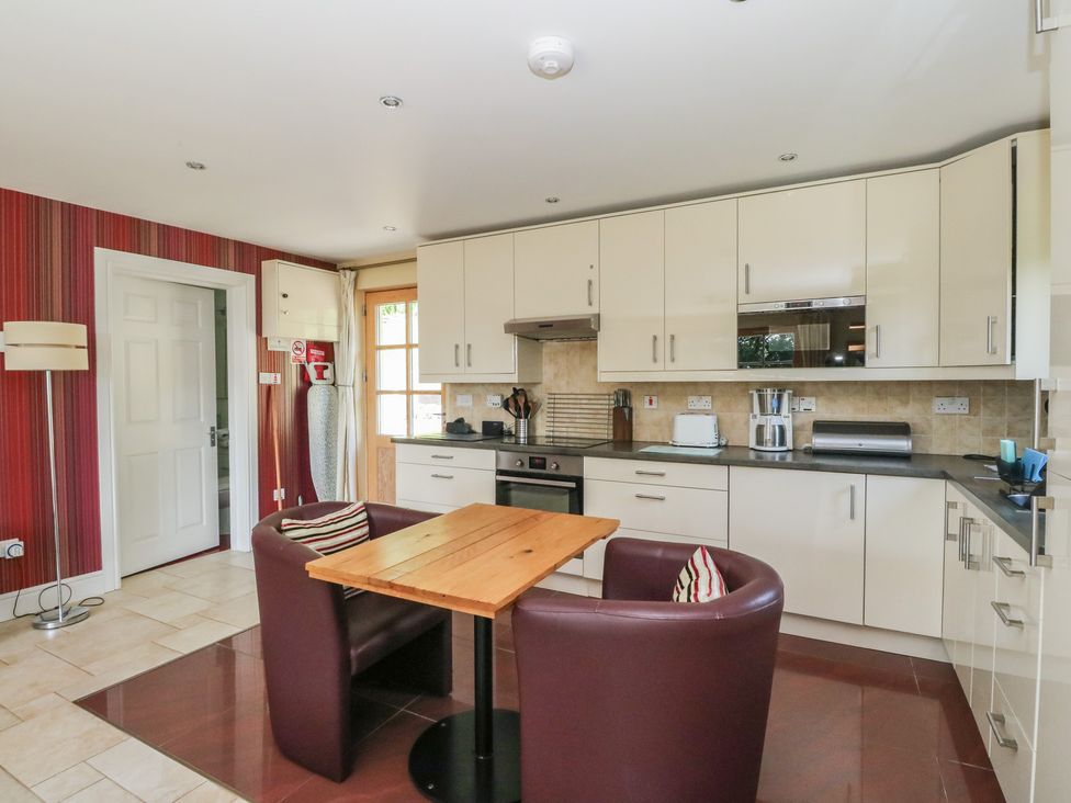 A kitchen with table and chairs at Ettrick Cottage in Rothesay