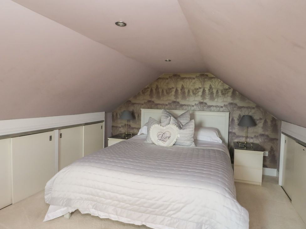A bedroom with a bed and storage units at Ettrick Cottage Rothesay