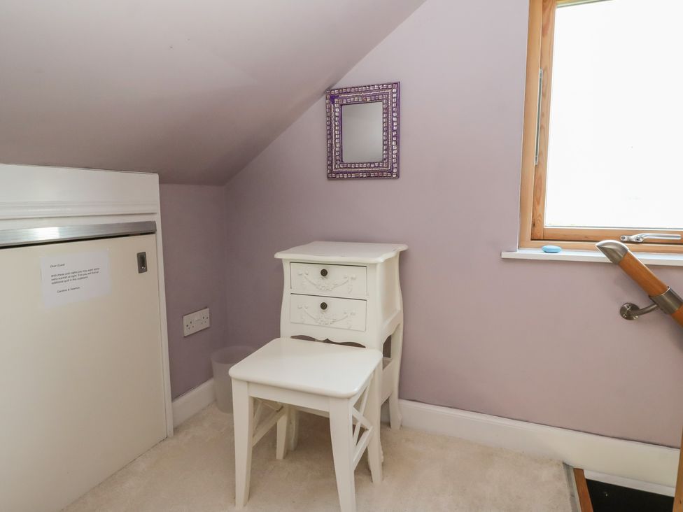 A room with a table and stool under a window at Ettrick Cottage in Rothesay