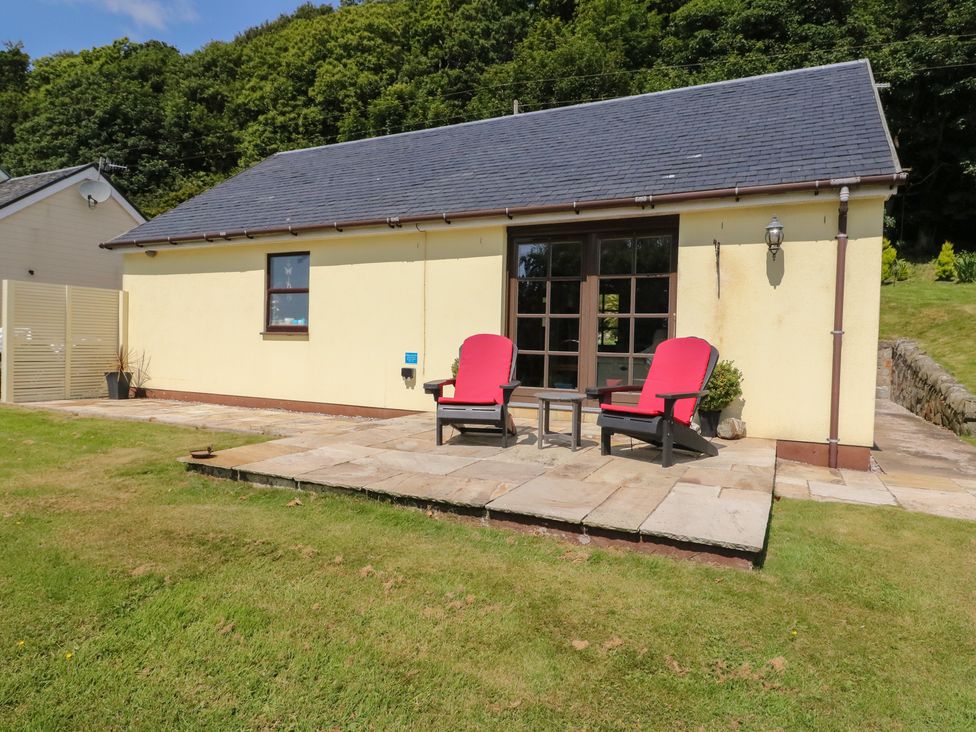 A patio with chairs and a table at Ettrick Cottage Rothesay