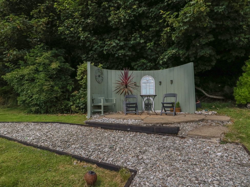 A garden seating area with chairs and table at Ettrick Cottage in Rothesay
