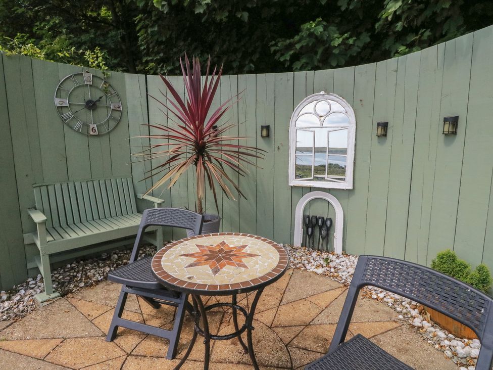 A garden with seating and a decorative wall at Ettrick Cottage Rothesay