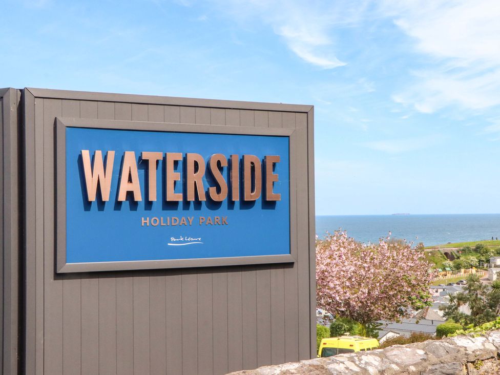 Sign for Waterside Holiday Park near the sea with trees in the background at Waterside Holiday Park