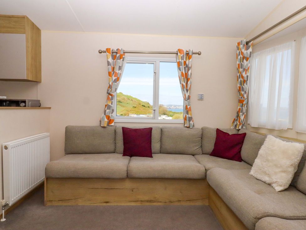 A living room with a corner sofa and window at 213 Seaview Caravan