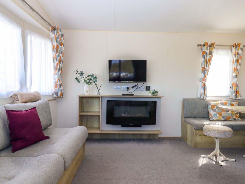 A living room with a television and sofa at 213 Seaview Caravan