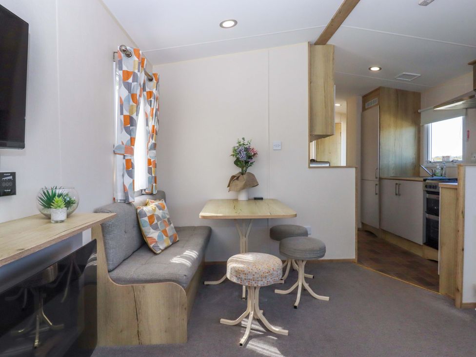 A dining area with a table and chairs at 213 Seaview Caravan
