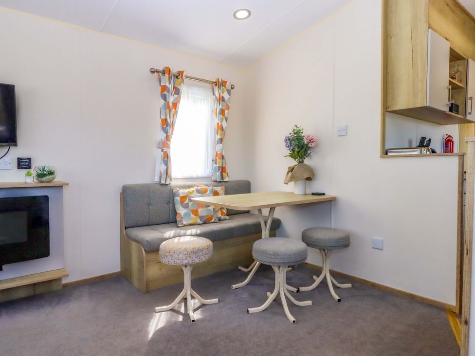 A snug room with a sofa and table at 213 Seaview Caravan