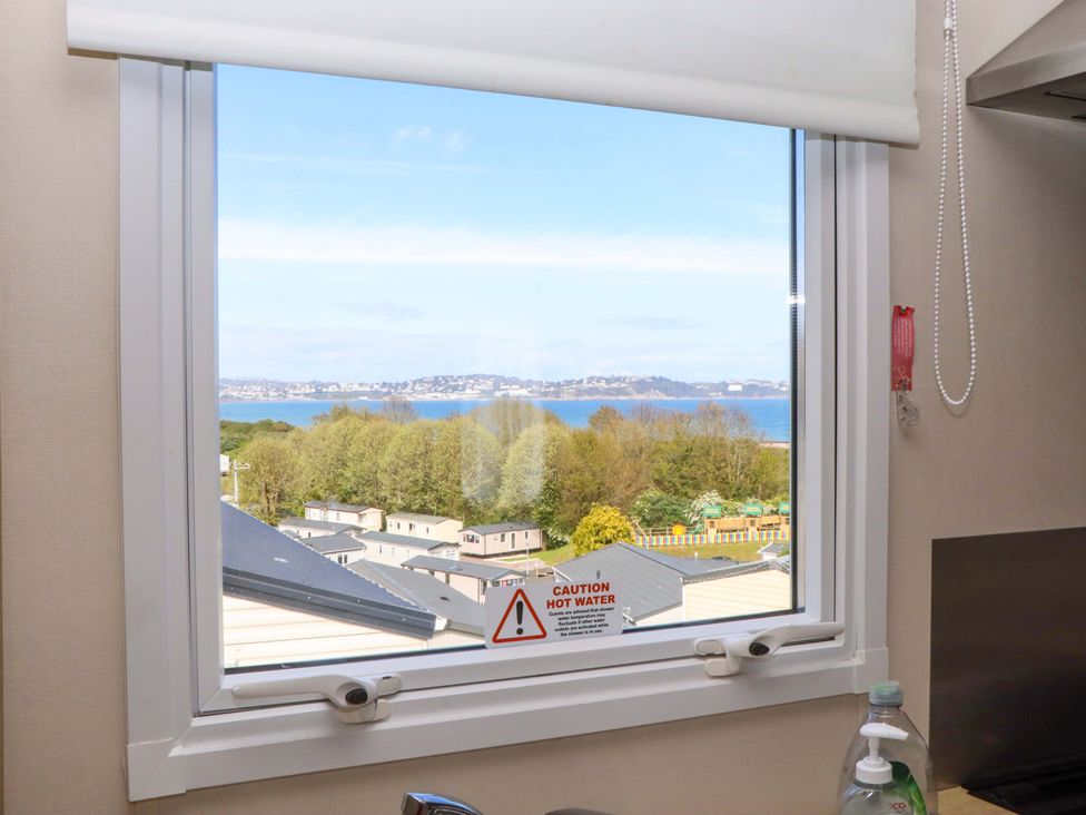 A window with views of water and trees at 213 Seaview Caravan