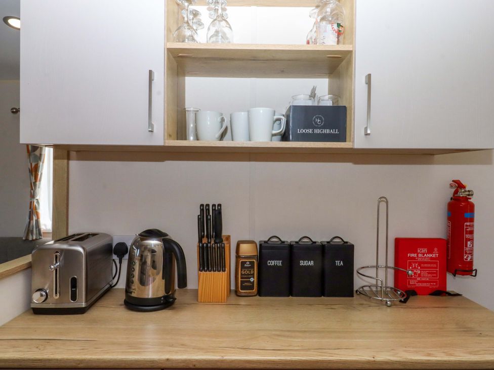 A kitchen counter with appliances and storage at 213 Seaview Caravan
