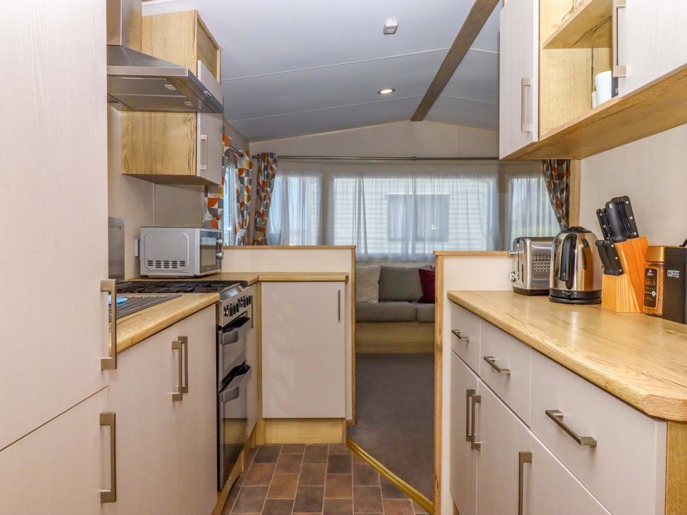 A kitchen with appliances and cabinets at 213 Seaview Caravan 