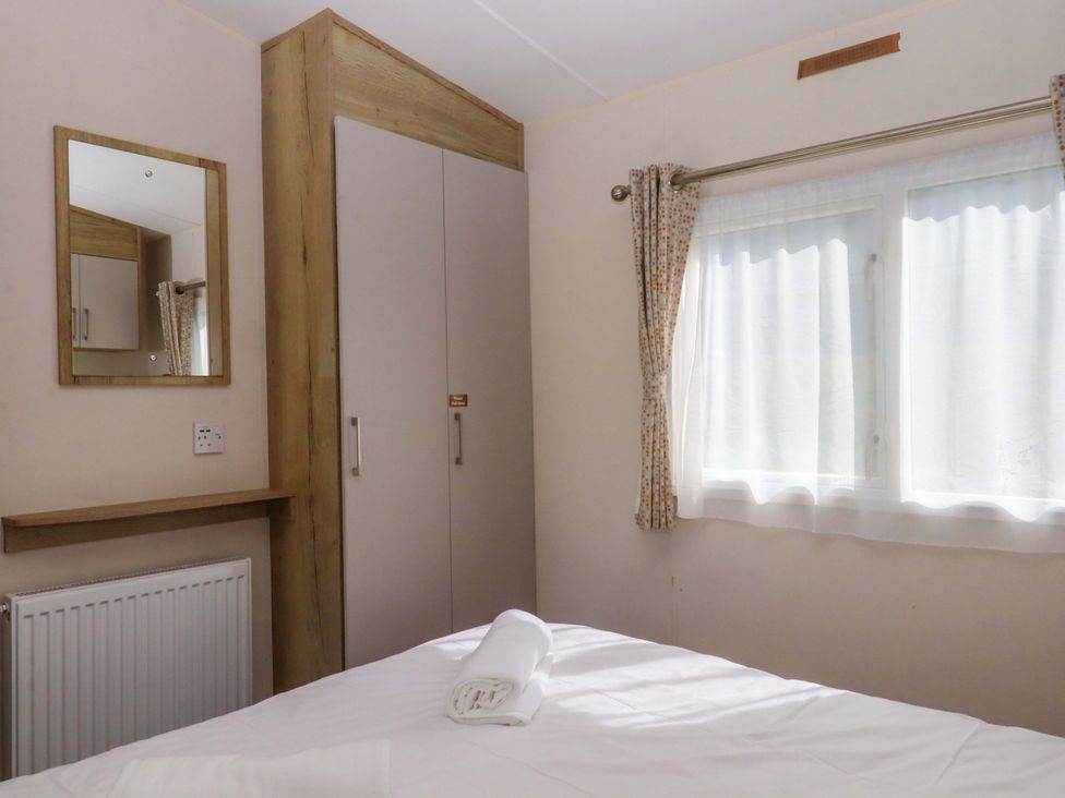 A bedroom with a mirror and wardrobe at 213 Seaview Caravan