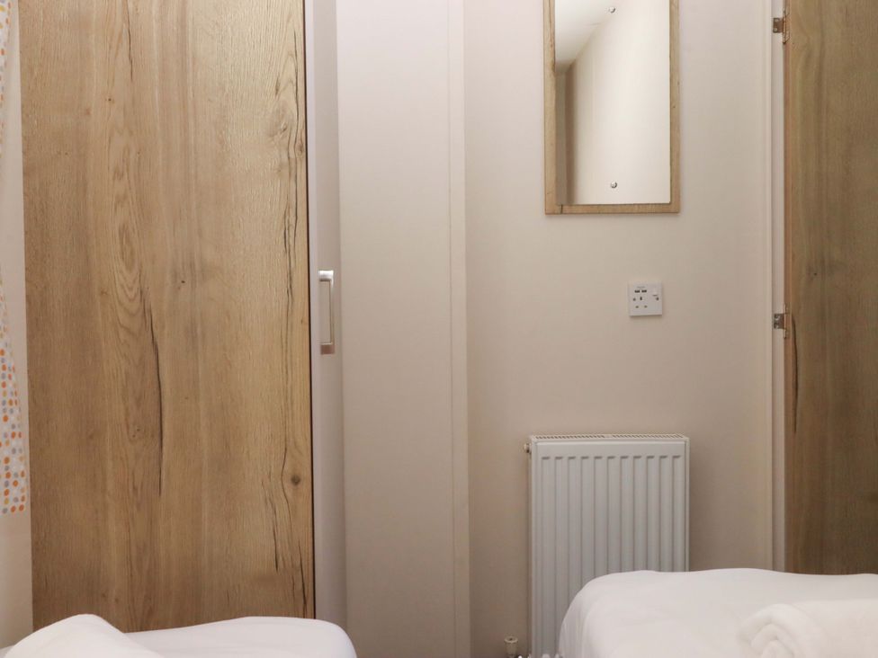 A bedroom with a mirror and a bed at 213 Seaview Caravan