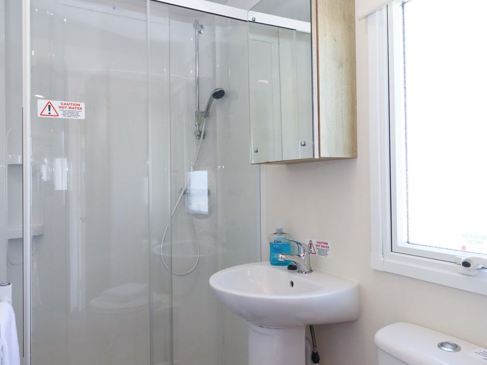 A bathroom with a shower and sink at 213 Seaview Caravan